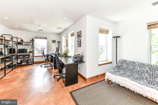 office area featuring finished concrete flooring, baseboards, visible vents, and a wealth of natural light