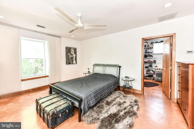 bedroom featuring a spacious closet, concrete floors, visible vents, and baseboards