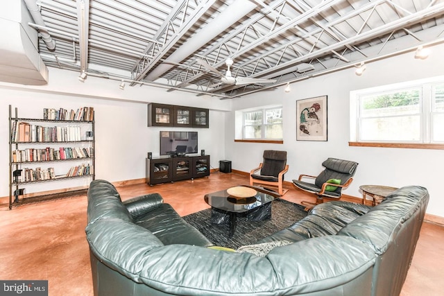 living room featuring concrete flooring and baseboards