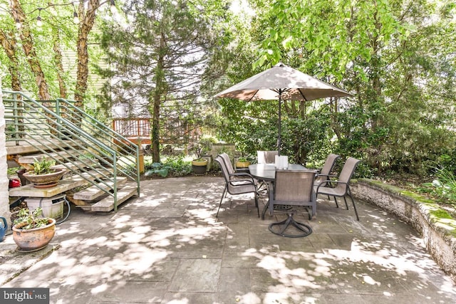 view of patio with outdoor dining area and stairway