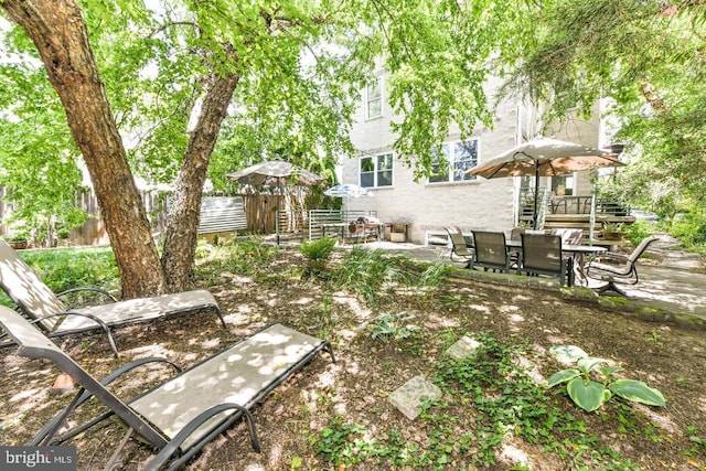 view of yard with outdoor dining space, a patio area, and fence