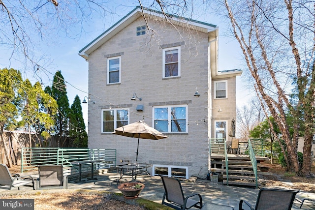 rear view of house featuring a patio and fence