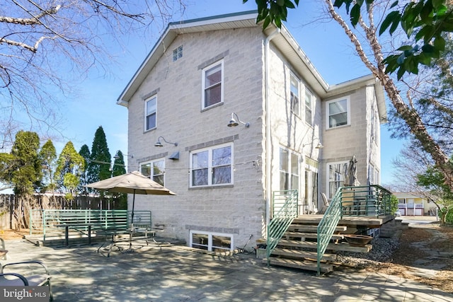 rear view of house featuring a patio area and fence