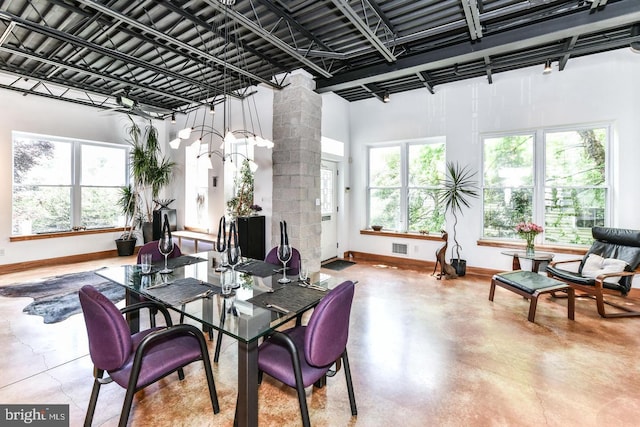 dining room with visible vents, concrete floors, baseboards, and decorative columns