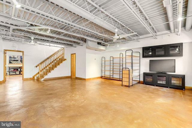 interior space featuring stairway, finished concrete flooring, and baseboards