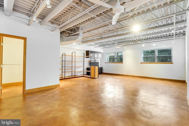 interior space with a ceiling fan and baseboards