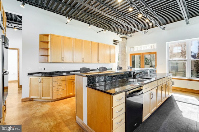 kitchen featuring a sink, light brown cabinets, dishwasher, and a towering ceiling