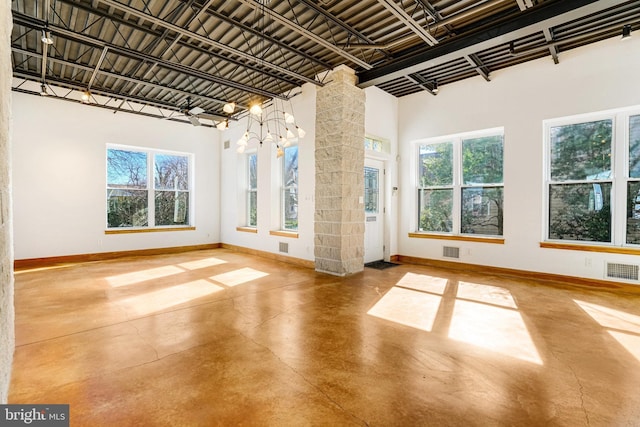 spare room with concrete flooring, ornate columns, visible vents, and baseboards