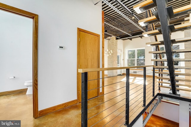 hall with concrete floors and baseboards