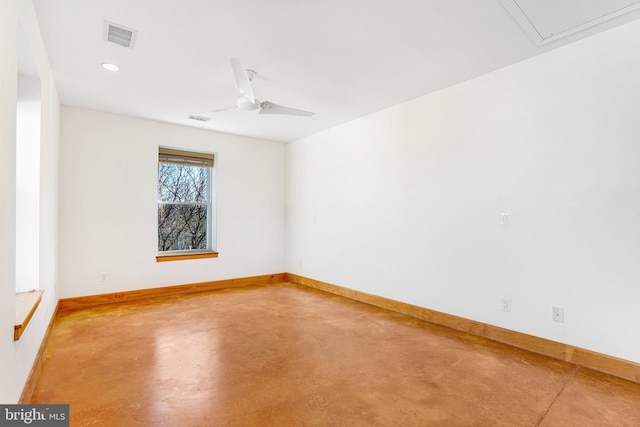 spare room featuring a ceiling fan, visible vents, concrete floors, and baseboards