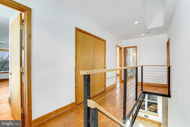 corridor with an upstairs landing, baseboards, and recessed lighting