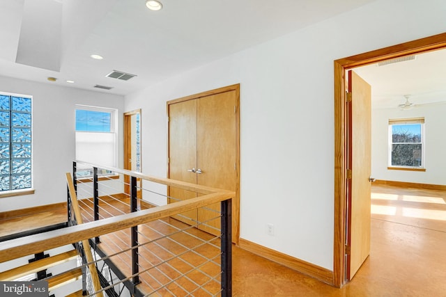 hallway with recessed lighting, baseboards, visible vents, and an upstairs landing