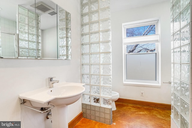 bathroom with toilet and baseboards