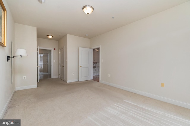 unfurnished bedroom with light colored carpet and ensuite bathroom