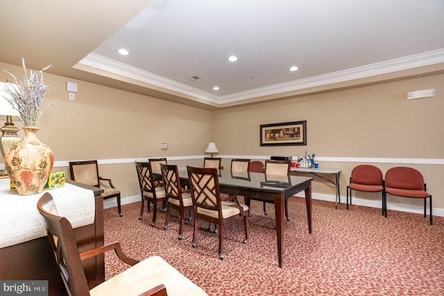 carpeted dining room featuring crown molding and a tray ceiling