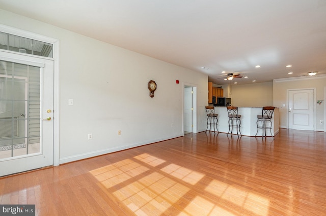 unfurnished living room with ceiling fan and light wood-type flooring