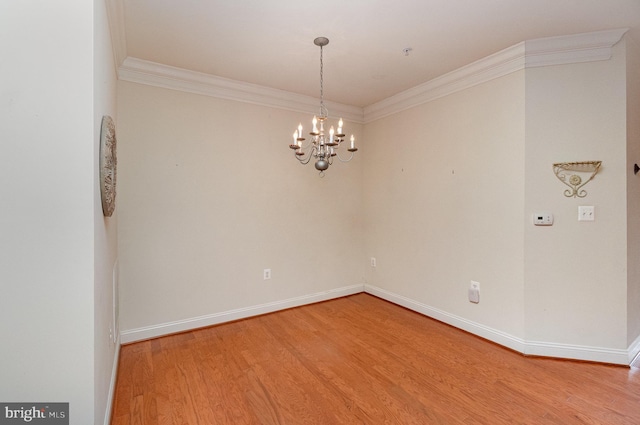 unfurnished room with hardwood / wood-style floors, crown molding, and a chandelier