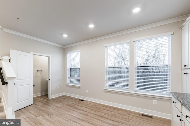 bedroom with ornamental molding and light hardwood / wood-style floors