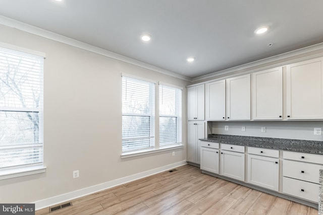 kitchen with white cabinetry, crown molding, and light wood-type flooring