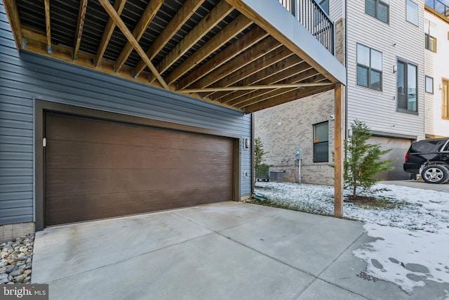 snow covered garage featuring central air condition unit