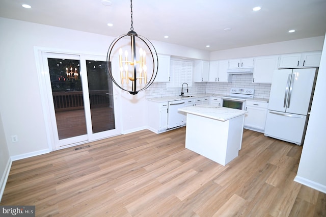 kitchen with a kitchen island, white cabinetry, and white appliances