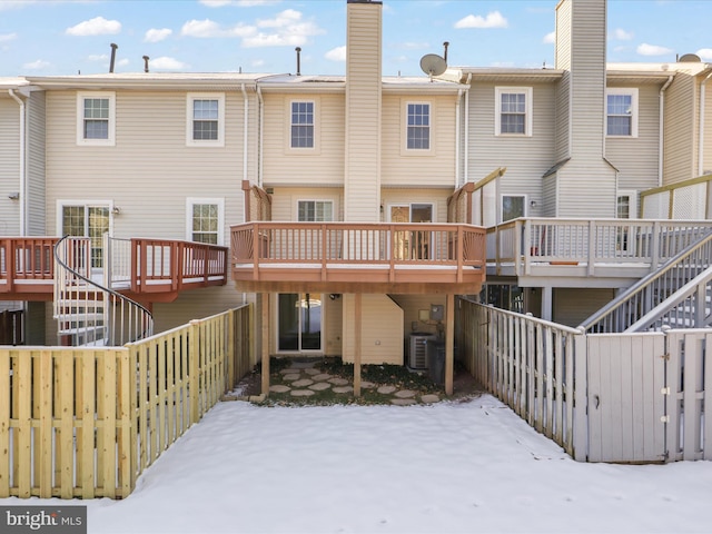 snow covered house featuring central air condition unit