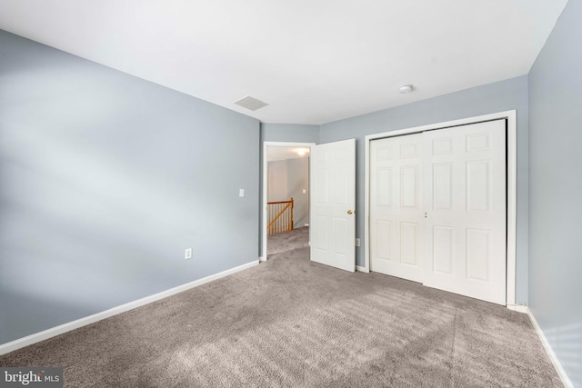 unfurnished bedroom with a closet and carpet flooring