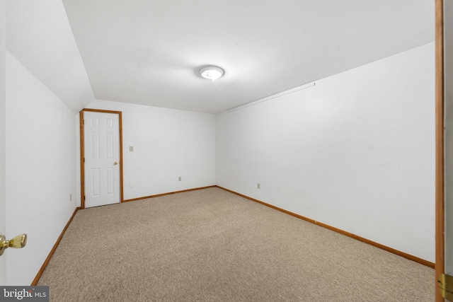 carpeted empty room with lofted ceiling