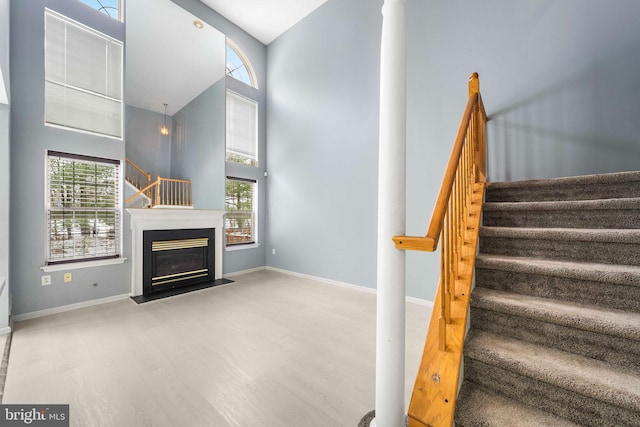 stairs with a high ceiling and hardwood / wood-style floors