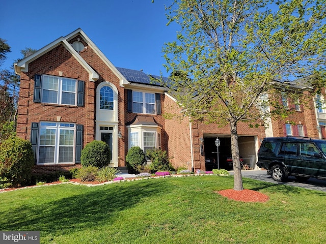 view of front of home featuring solar panels and a front yard