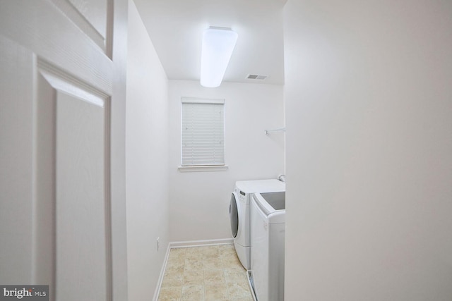 clothes washing area featuring baseboards, laundry area, visible vents, and washer and dryer