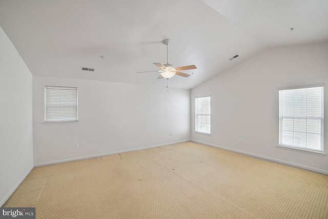 unfurnished room with ceiling fan, light colored carpet, visible vents, baseboards, and vaulted ceiling