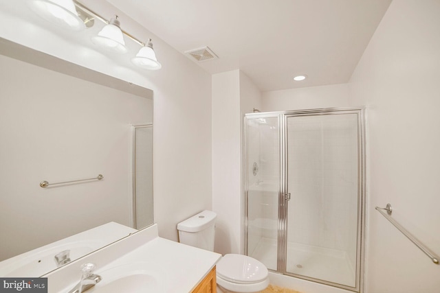 bathroom with a stall shower, visible vents, vanity, and toilet