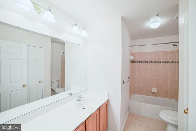 bathroom featuring toilet, bathing tub / shower combination, vanity, and tile patterned floors