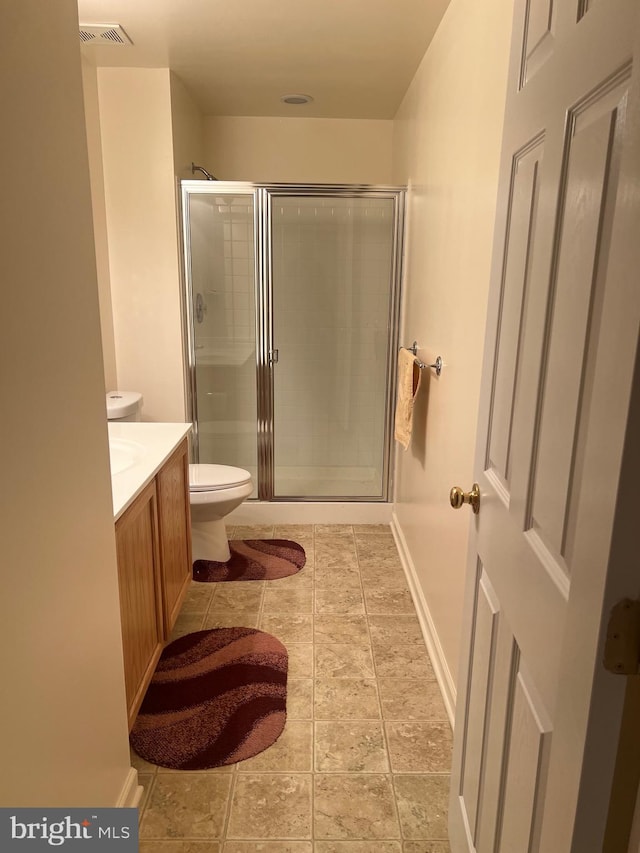 full bath with visible vents, baseboards, toilet, vanity, and a shower stall