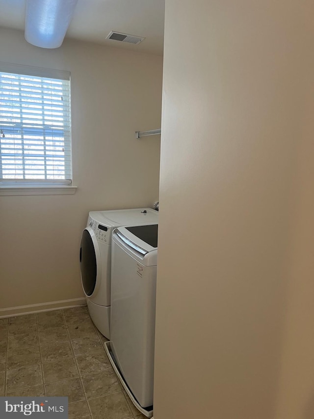 laundry area with laundry area, baseboards, visible vents, washer and clothes dryer, and tile patterned floors