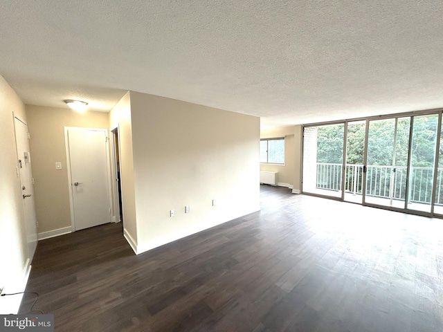 unfurnished room featuring a textured ceiling, dark hardwood / wood-style floors, and floor to ceiling windows