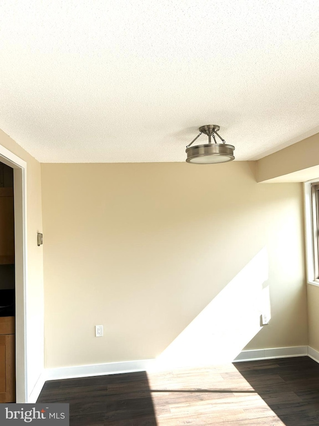 interior space featuring a textured ceiling and dark hardwood / wood-style flooring