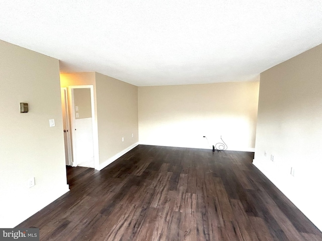 unfurnished room with dark hardwood / wood-style flooring