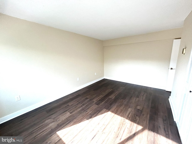 spare room with dark hardwood / wood-style flooring