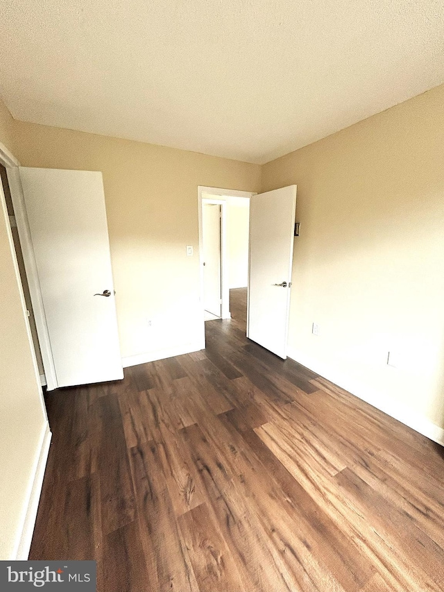 spare room with dark wood-type flooring