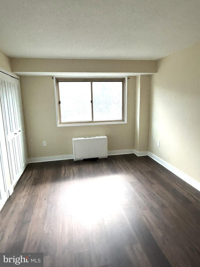 interior space featuring a textured ceiling, radiator, and dark hardwood / wood-style flooring