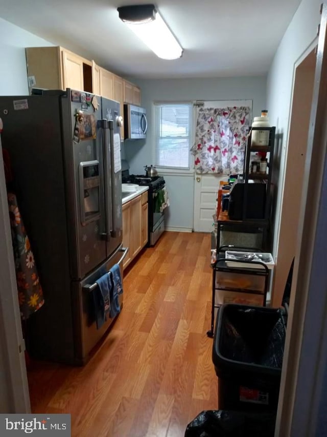 kitchen featuring appliances with stainless steel finishes, light brown cabinetry, and light hardwood / wood-style floors