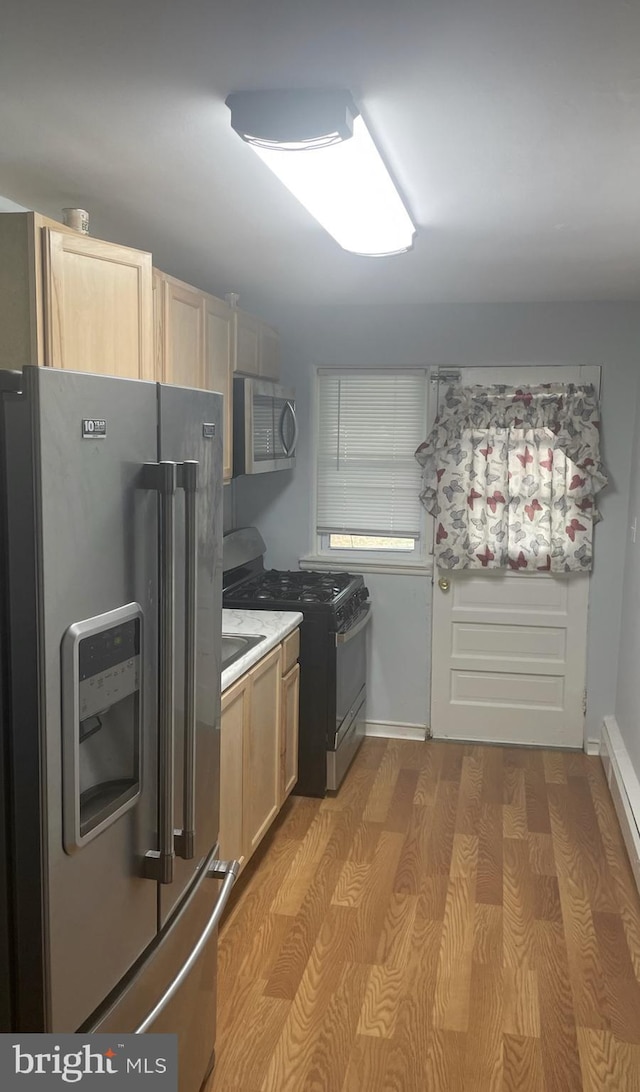 kitchen featuring appliances with stainless steel finishes, light brown cabinetry, and light hardwood / wood-style flooring