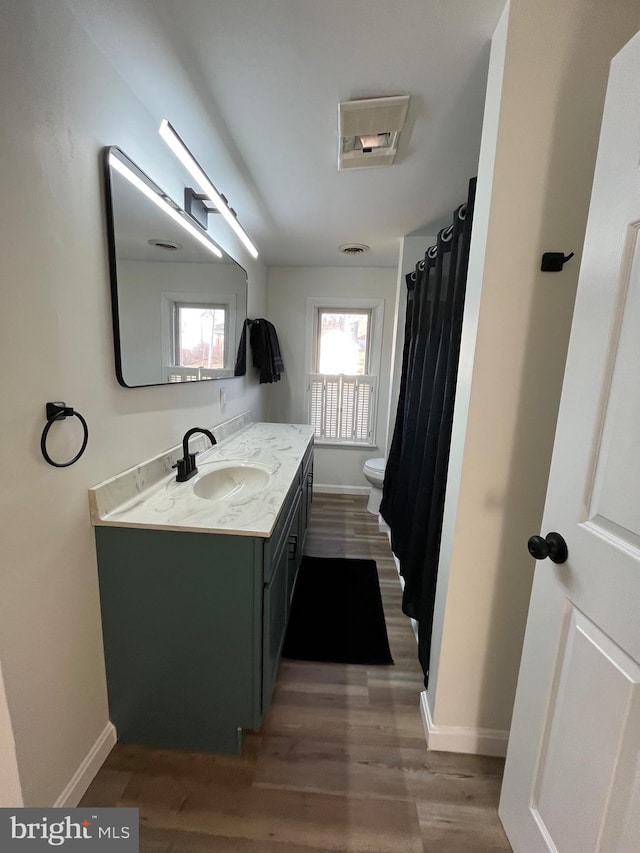 bathroom with vanity, hardwood / wood-style floors, and toilet