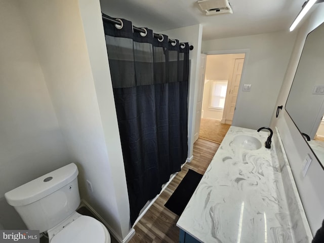 bathroom featuring hardwood / wood-style flooring, vanity, and toilet