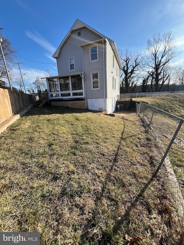 back of house with a sunroom and a yard