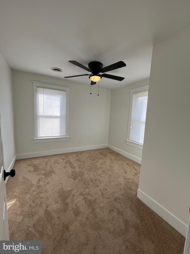 carpeted empty room featuring ceiling fan