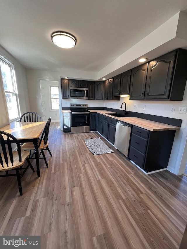 kitchen featuring stainless steel appliances, sink, and light wood-type flooring