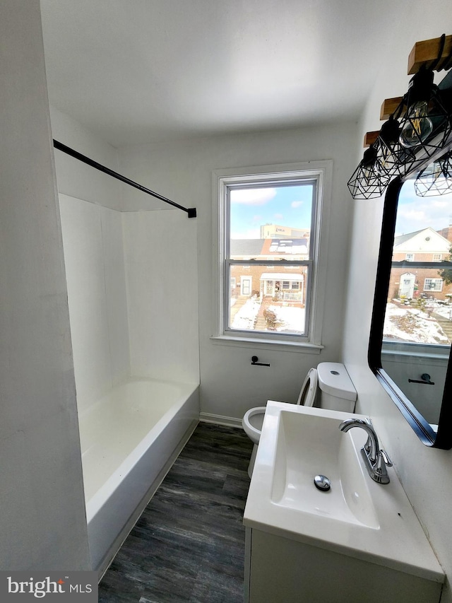 full bathroom with hardwood / wood-style flooring, vanity, toilet, and shower / bathing tub combination